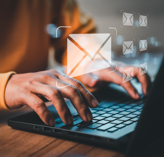 An envelope hovering over a hand and laptop, representing JTF Marketing’s expertise in creating optimized and high-performing email templates.