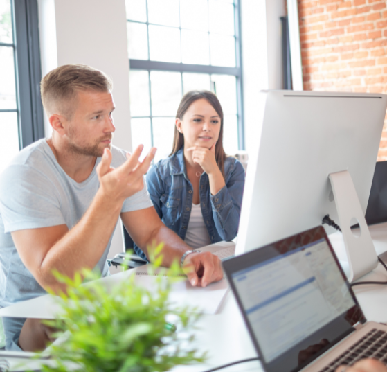 A man and woman looking at a screen, collaborating on a MarTech strategy, representing JTF Marketing’s expertise in optimizing marketing technology.