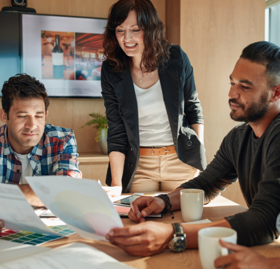 A group of professionals gathered around a table, reviewing templates, representing JTF Marketing’s expertise in program templates and streamlined campaign execution.